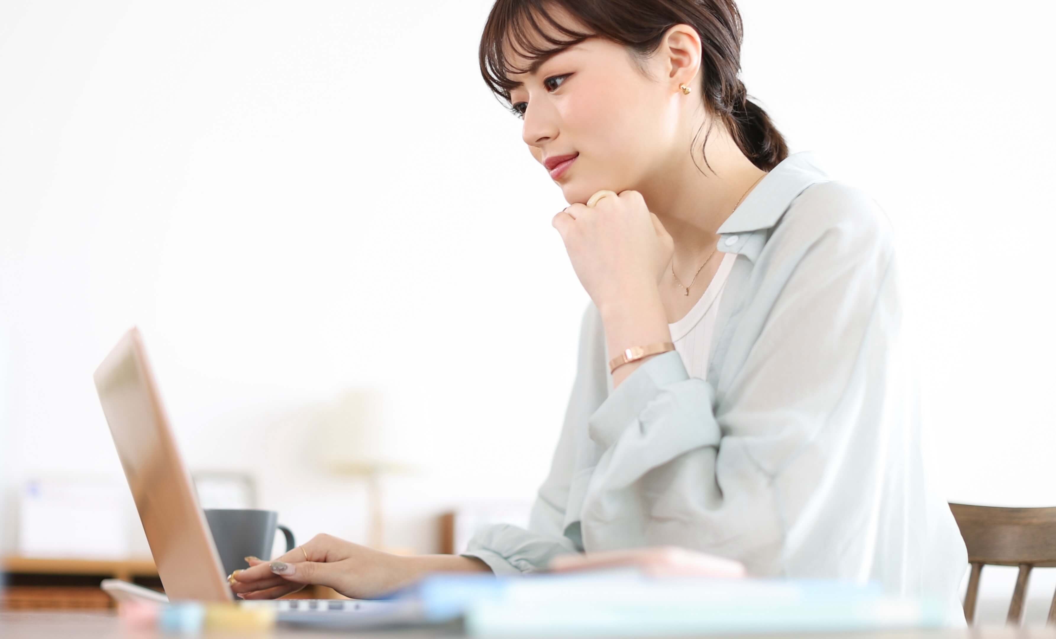 ノートパソコンでサイトを確認する女性